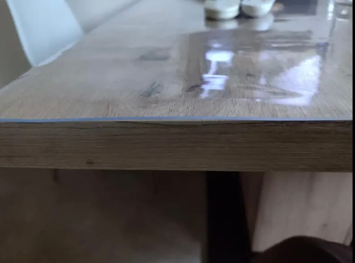 Nahaufnahme der Tischkante: der dünne Rand der Matte endet bündig über dem Holz