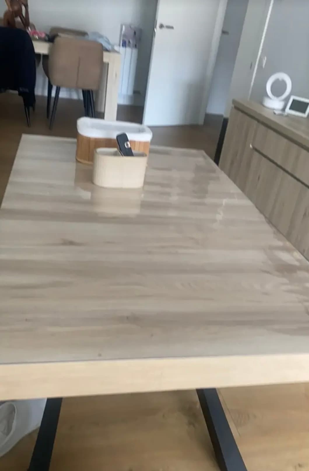 Heller Wohnzimmertisch mit Holzbehältern; die Matte reflektiert das Licht vom Fenster