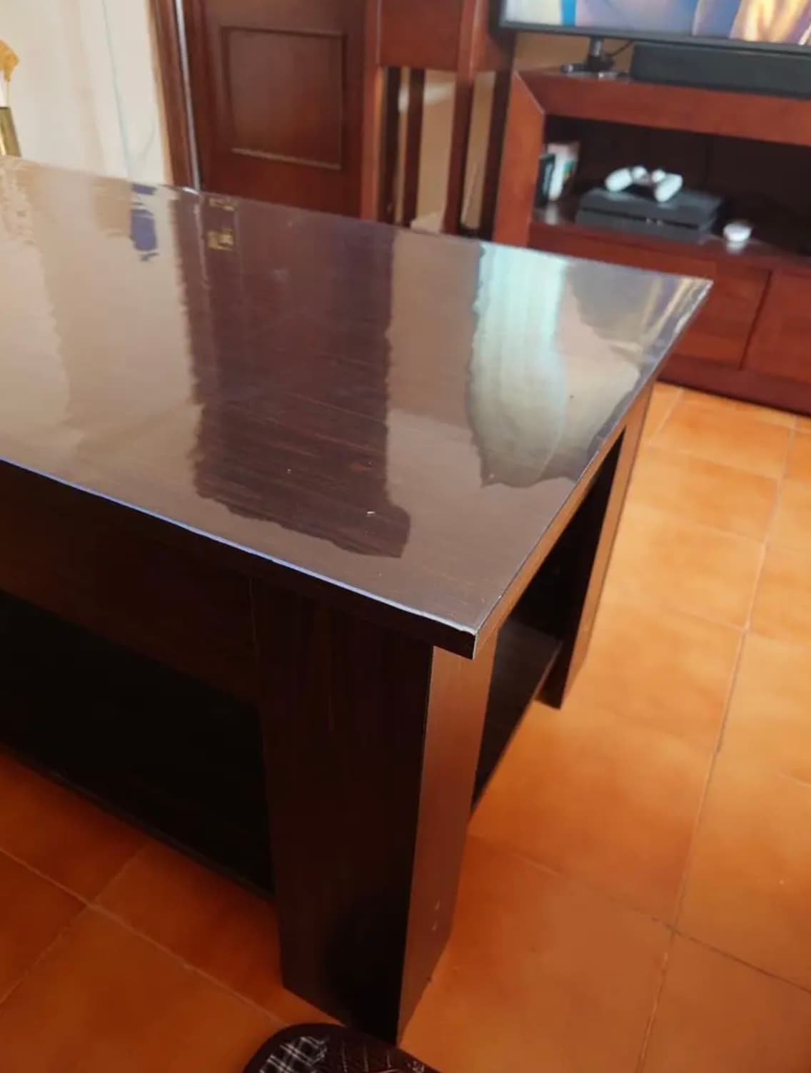 Dunkle Wenge-Konsole im Wohnzimmer, die Platte unter transparenter Matte, auf dem Boden Terrakotta